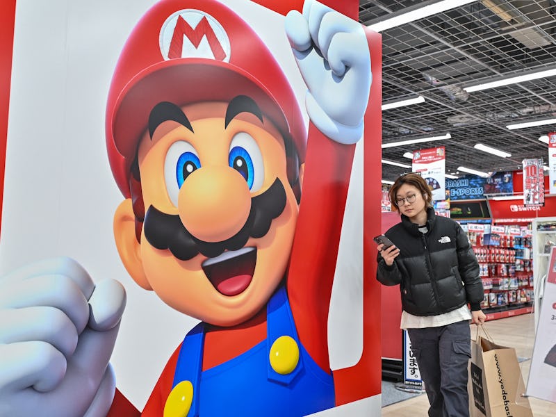 This photo taken on January 12, 2024 shows a customer walking past a display for Super Mario by the ...