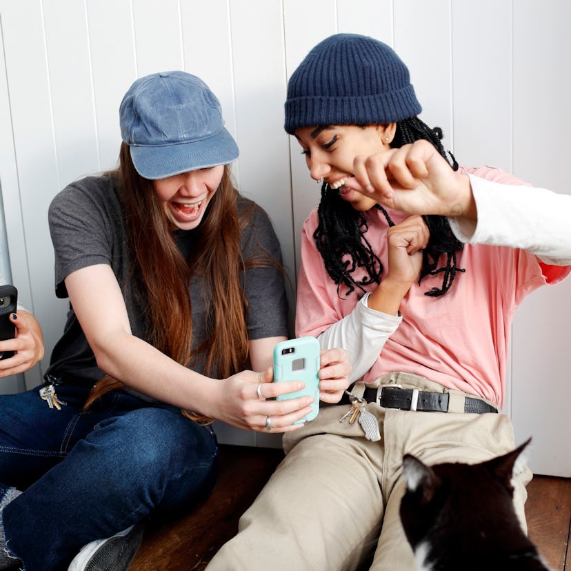 Two young friends looking up what a sextile is in astrology on their phone.