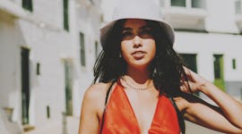 A young woman walking down the street on a hot day during one of July 2023's planetary retrogrades.